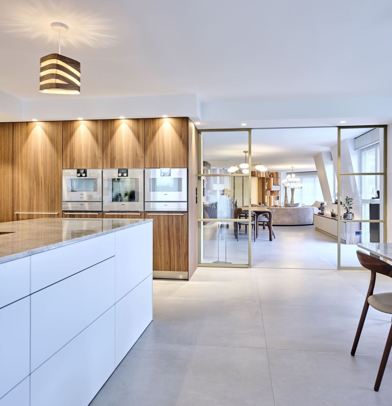 Cuisine Bulthaup haut de gamme ouverte sur la salle à manger, intégrée au projet VEFA
